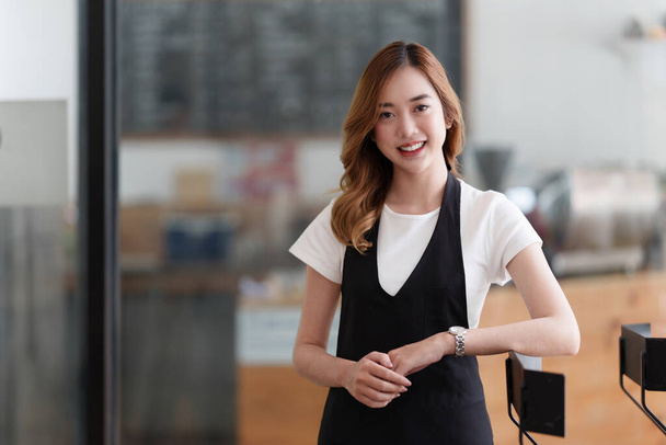 Beautiful Asian women Barista smiling at her cafe waiting for customer. - Photo, image