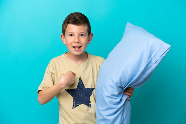 Menino de pijama isolado em fundo azul com expressão facial surpresa - Foto, Imagem