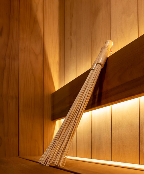 Bamboo broom close up. Sauna accessories in the steam room - Zdjęcie, obraz