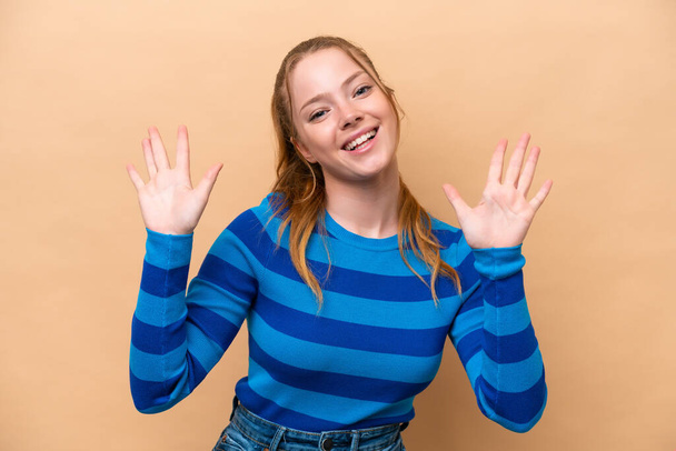 Νεαρή καυκάσια γυναίκα απομονωμένη σε μπεζ φόντο μετρώντας δέκα με δάχτυλα - Φωτογραφία, εικόνα