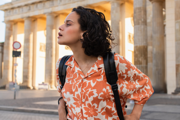 amazed traveler with backpack looking away near ancient columns in berlin  - Fotó, kép