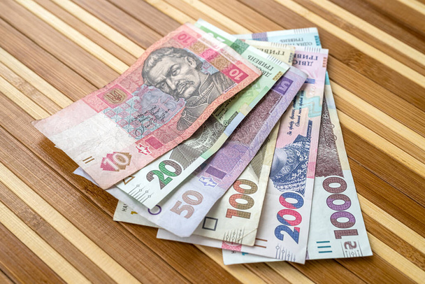 κορυφαία άποψη για πολλά Ουκρανικά εθνικού νομίσματος στο τραπέζι. Η έννοια του πλούτου και των κερδών - Φωτογραφία, εικόνα