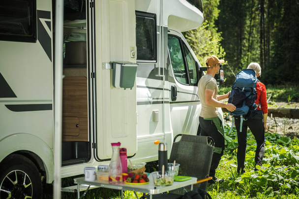 Caucasian Camping Couple Next to Their Class C Motor Home. Preparing For a Hike. Recreational Vehicles Theme. - Foto, immagini