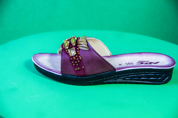 Illustrative Editorial branded photography, Slipper shouted on green Background, shot is selective focus with shallow depth of field. Photos taken at Cairo Egypt on 28 March 2019 - Zdjęcie, obraz