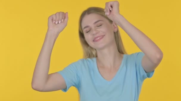 Випадкова молода жінка танцює в радості на жовтому тлі
  - Кадри, відео