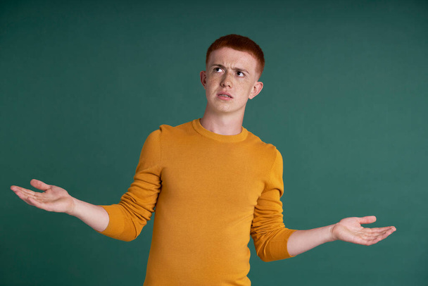 Разочарованный кавказский подросток с рыжими волосами и вытянутыми руками - Фото, изображение