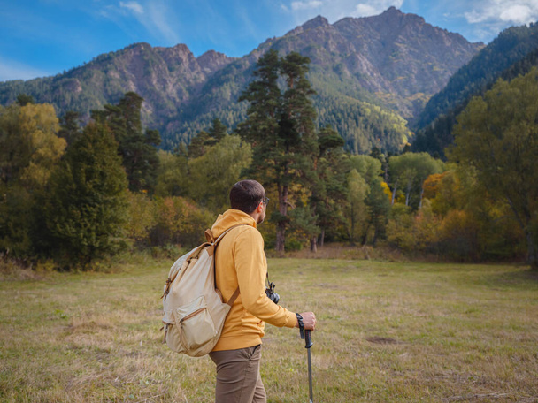 trip to Caucasus mountains, Arkhyz, Teberdinsky reserve. concept of discovery and exploration of wild places in early autumn. Man hiking in mountains with backpack and photo camera - Photo, Image