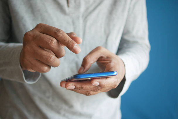 Крупный план руки молодого человека с помощью смартфона - Фото, изображение