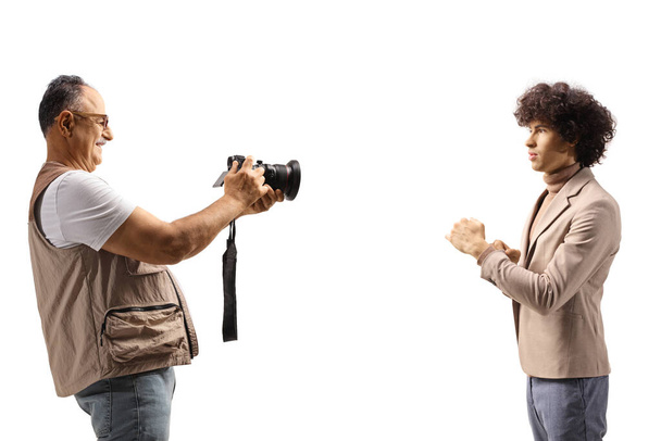 Photographer taking a photo of a young male model isolated on white background - Fotó, kép