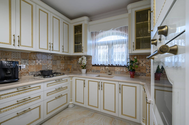 Λευκή κλασική ζεστή κουζίνα και τραπεζαρία στο εσωτερικό του σπιτιού της πόλης - Φωτογραφία, εικόνα