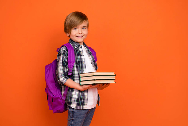 Profile side photo of young boy hold book information materials isolated over orange color background. - Valokuva, kuva