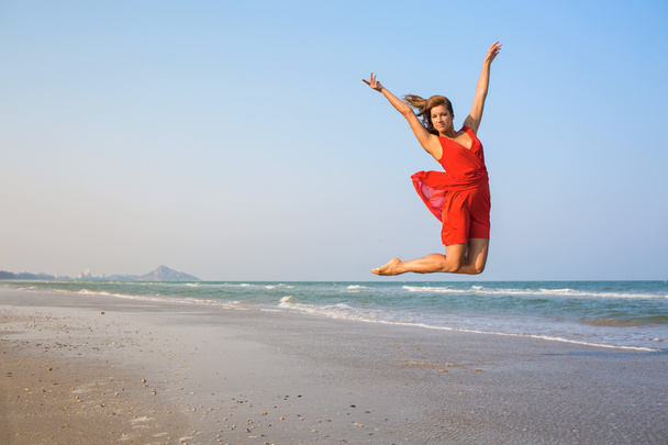 Сексуальная девушка в красном платье прыгает
 - Фото, изображение