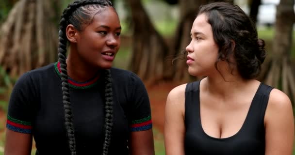 Casual hispanic and African girl friends talking outside - Felvétel, videó