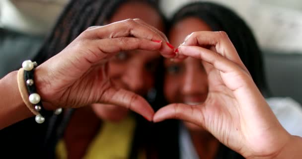 Misto razza madre e giovanissima figlia making cuore simbolo con mani - Filmati, video
