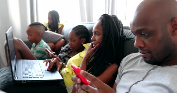 Famiglia nera casuale che utilizza la tecnologia a casa. Donna africana che guarda video su laptop - Filmati, video