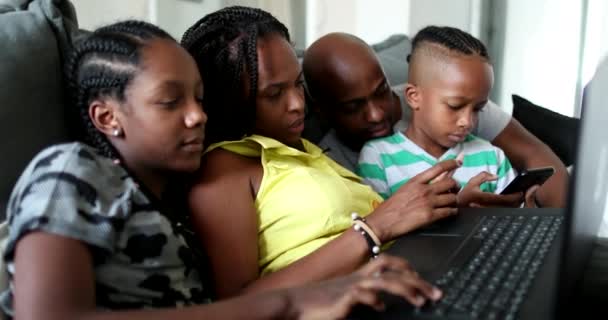 Afrikalı ebeveynler ve çocuklar teknolojiyi evde kullanıyorlar. Anne, baba ve çocuklar dizüstü bilgisayarın önünde. - Video, Çekim