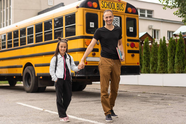first day at school. father leads a little child school girl in first grade - Photo, Image