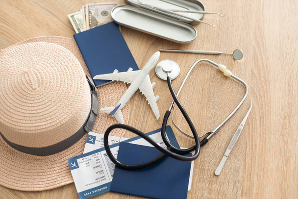 Medical Tourism, medical travel concept. Stethoscope, toy plane and passport on wooden background. - Foto, Imagem