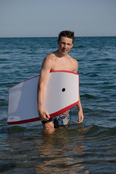 A 17 Year Old Teenage Boy In The Sea With A Body Board - Foto, afbeelding