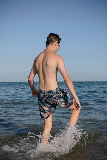 A 17 Year Old Teenage Boy Walking Into The Sea - Φωτογραφία, εικόνα