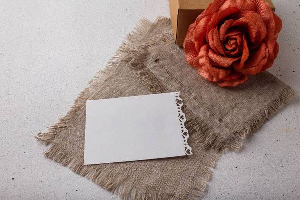 Barna papír ajándék doboz, szövet rózsa virág, üres képeslap fehér háttérrel. Valentin nap, születésnap vagy esküvő meglepetés - Fotó, kép