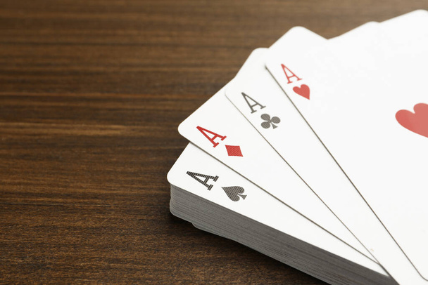 Four aces playing cards on wooden table, closeup. Space for text - Фото, зображення