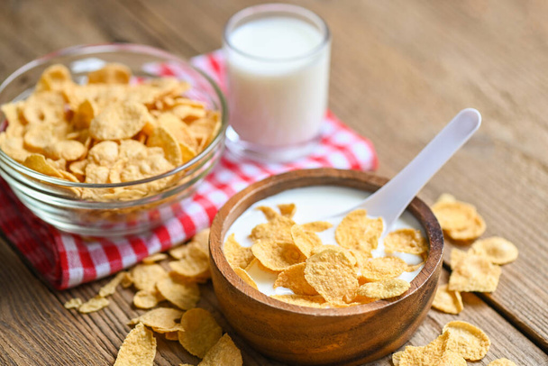 Cornflakes with milk on wooden table background, cornflakes bowl breakfast food and snack for healthy food concept, morning breakfast fresh whole grain cereal - 写真・画像