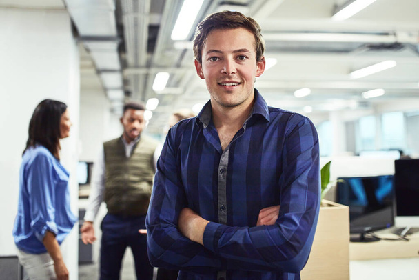 I have some big dreams to achieve. Portrait of a young designer standing in an office with his colleagues in the background - Foto, Imagen