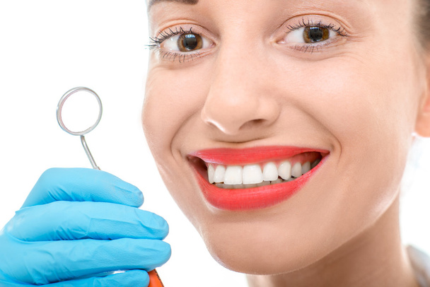 Mujer con espejo dental sobre fondo blanco
 - Foto, Imagen