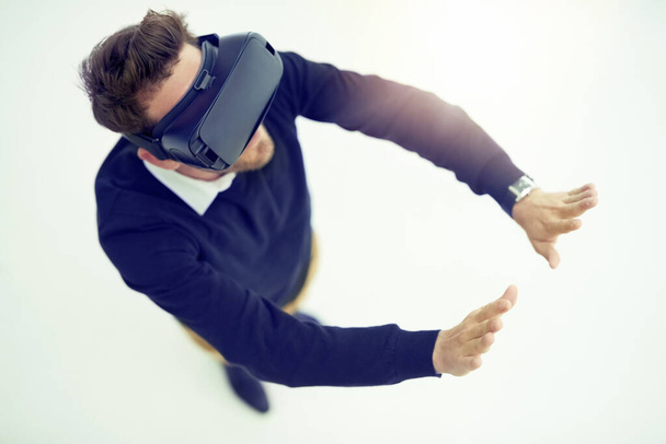 Change the way you see and experience the world. High angle shot of a businessman wearing a VR headset in an office - Foto, Imagem