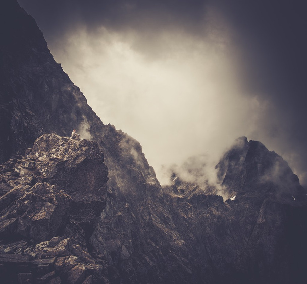 Nainen vaellus istuu vuoren huipulla
 - Valokuva, kuva
