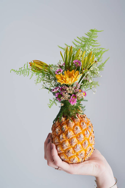 Stand tall, wear a crown, be sweet on the inside. Studio shot of an unrecognizable woman holding a pineapple against a grey background - Fotografie, Obrázek