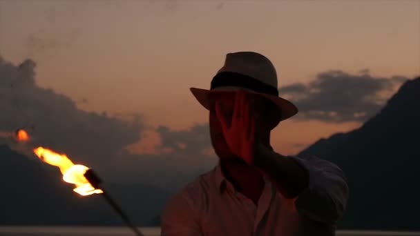 Молодий чоловік виконує вогняне шоу з факелом полум'я
 - Кадри, відео