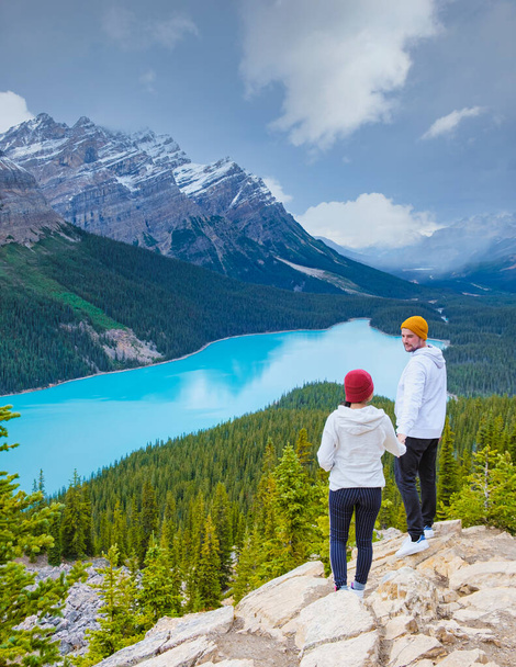 Lake Peyto in Banff National Park, Canada. Mountain Lake as a fox head is popular among tourists in Canada driving the icefields parkway. A couple of men and women looking out over the lake - Valokuva, kuva