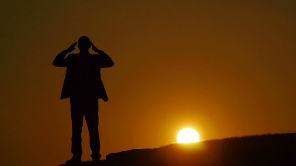 Σιλουέτα του ανθρώπου αυξάνοντας τα χέρια στο ηλιοβασίλεμα - Πλάνα, βίντεο