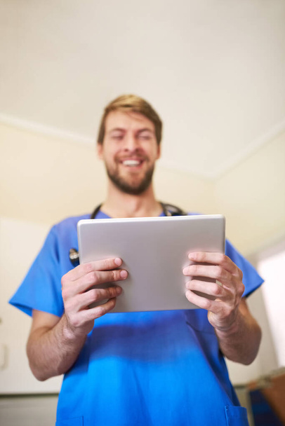 Отримання оновлень пацієнта на ходу. щасливий молодий лікар, використовуючи планшет у своєму офісі
 - Фото, зображення