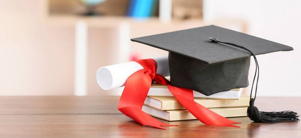 Graduation hat, diploma and books on table - Fotoğraf, Görsel