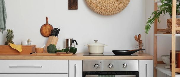Сучасна електрична плита з посудом та посудом на світлій кухні
 - Фото, зображення
