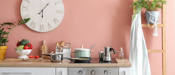Modern electric stove with cookware and utensils in cozy kitchen - Fotoğraf, Görsel