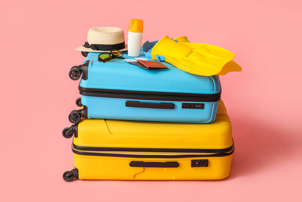 Suitcases, passports, tickets and beach accessories on pink background - Foto, immagini