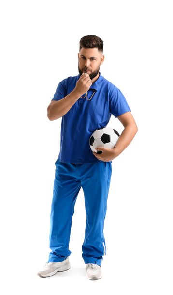 Красивый учитель физкультуры со свистом и мячом на белом фоне - Фото, изображение