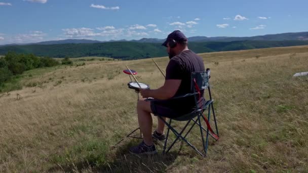 Artist with practice pads and headsets in summer meadow - Video, Çekim
