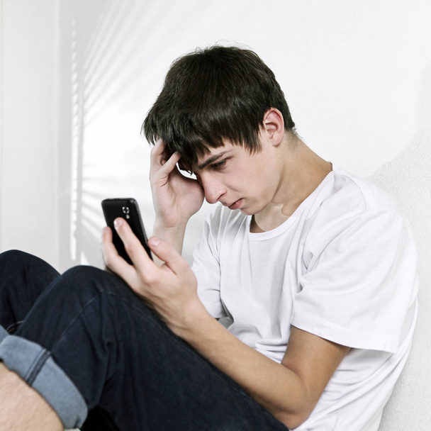 Sad Teenager with Cellphone - Photo, Image