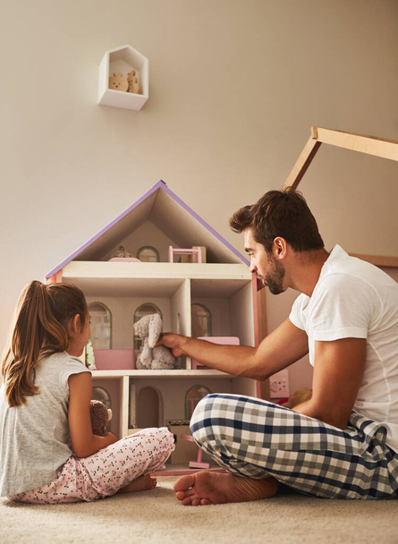 Hes a great father. a handsome young man and his daughter playing with her dollhouse - Fotó, kép
