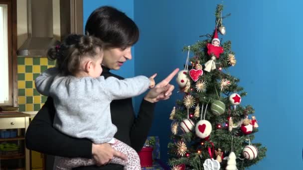 Familie mit glücklicher Mutter und Kind beim Blick auf Weihnachtsbaum - Filmmaterial, Video
