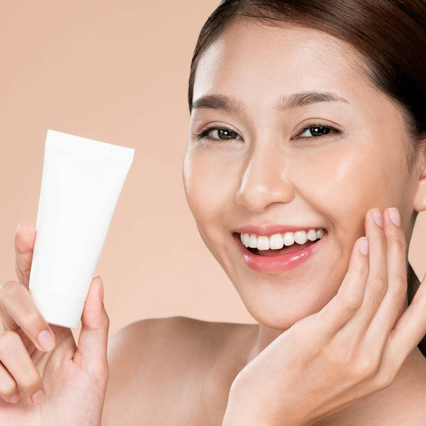 Closeup ardent woman smiling holding mockup product for advertising text place, light grey background. Concept of healthcare for skin, beauty care product for advertising. - Foto, Imagem