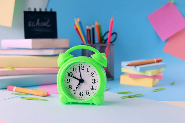 Stationery, alarm clock, books on a background of pastel colors of multi-colored paper, back to school, education - Foto, imagen