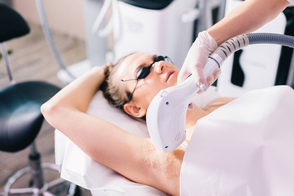 Woman on laser hair removal treatment on underarm. Skin and body care - Foto, imagen