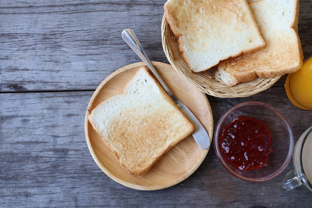 Breakfast of slice toast bread strawberry jam orange juice and coffee cup - Photo, image