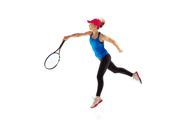 Portrait of young sportive woman, tennis player playing tennis isolated on white background. Healthy lifestyle, fitness, sport, exercise concept. Female athlete in motion, action or movement - Foto, afbeelding